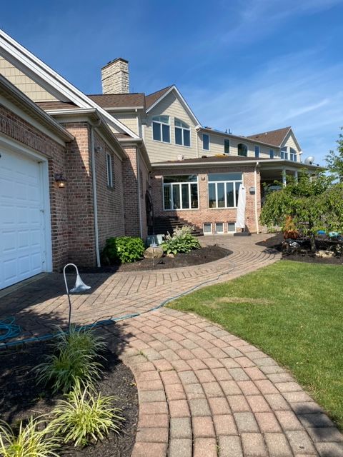 A large house with a brick walkway leading to it