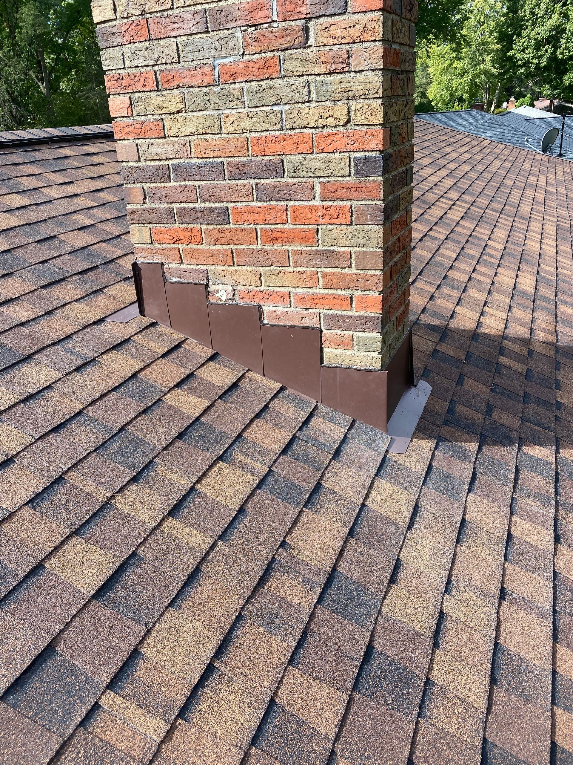A brick chimney is sitting on top of a roof.