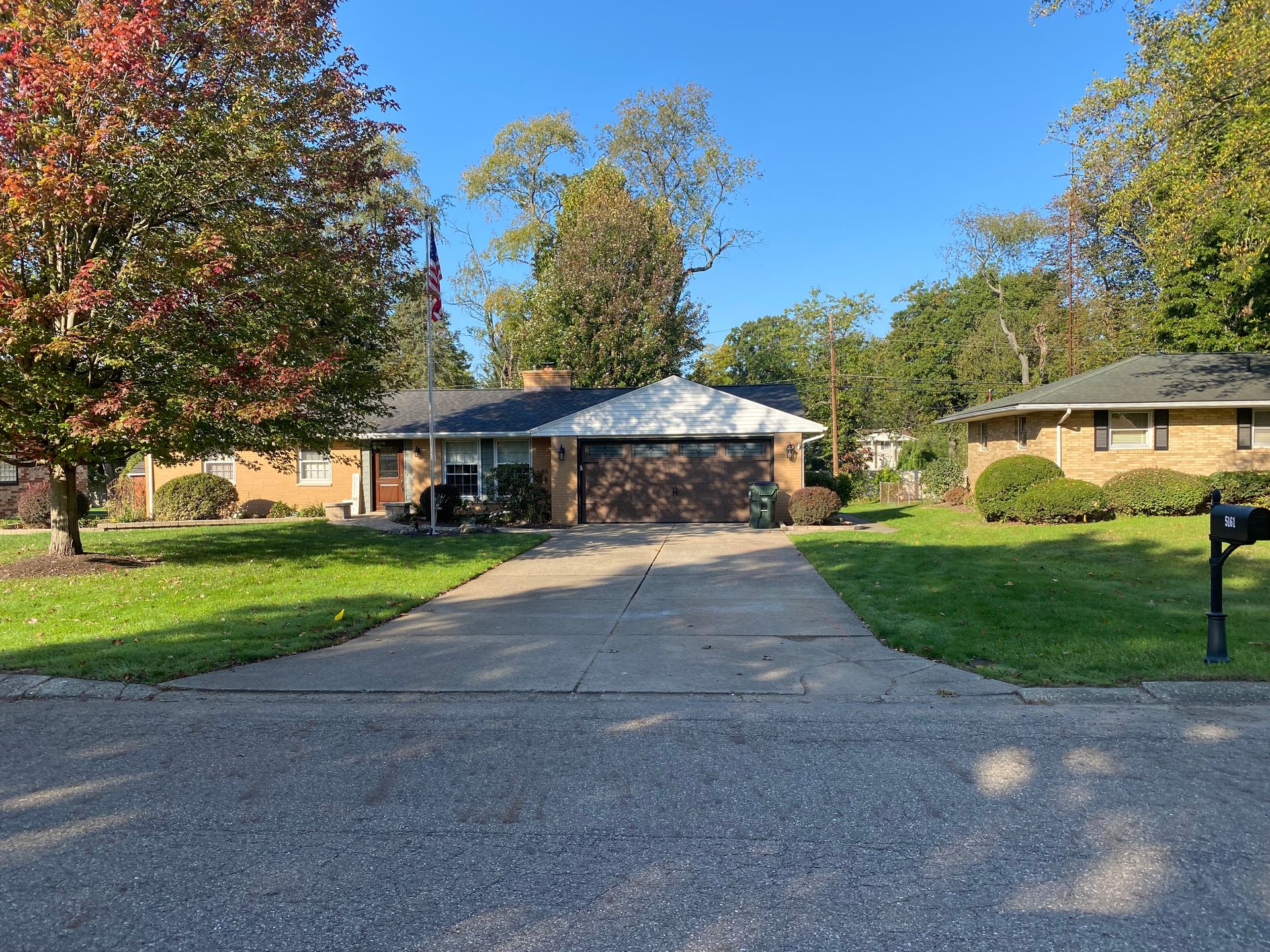 A house with a driveway and a mailbox in front of it.