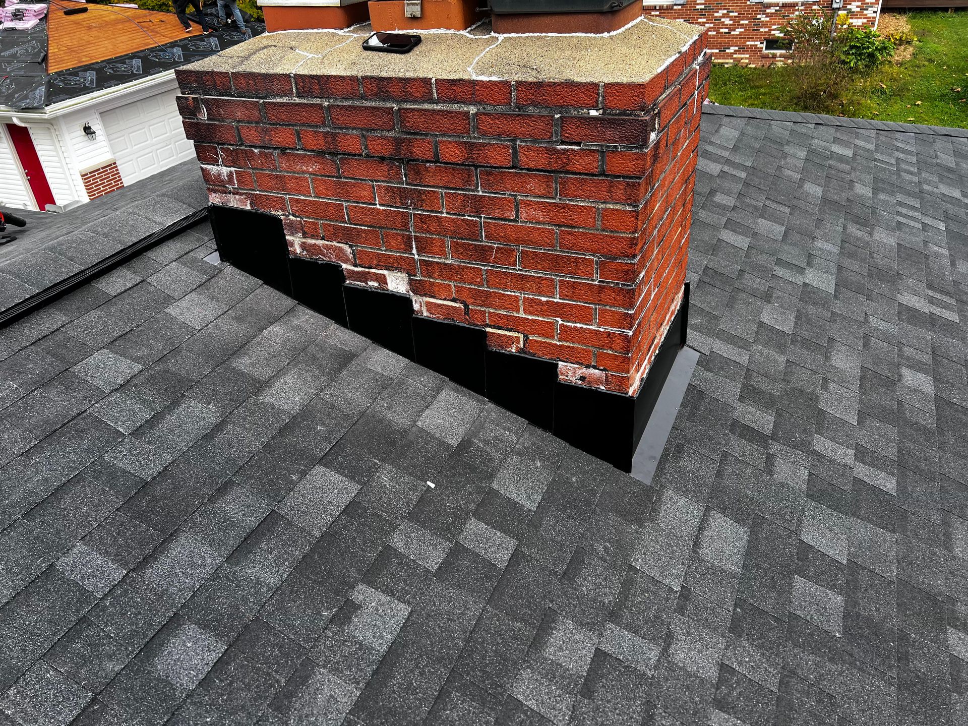 A brick chimney is sitting on top of a roof.