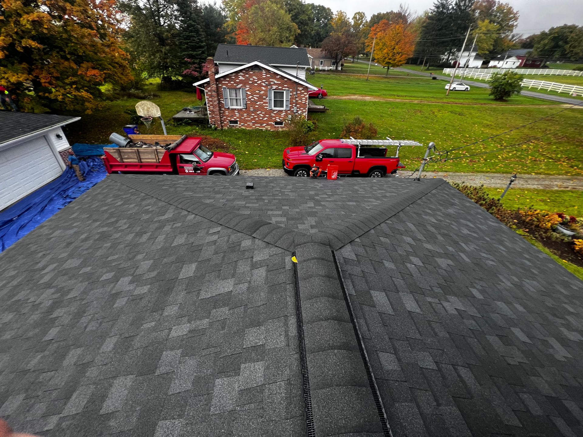 A red truck is parked on the roof of a house.