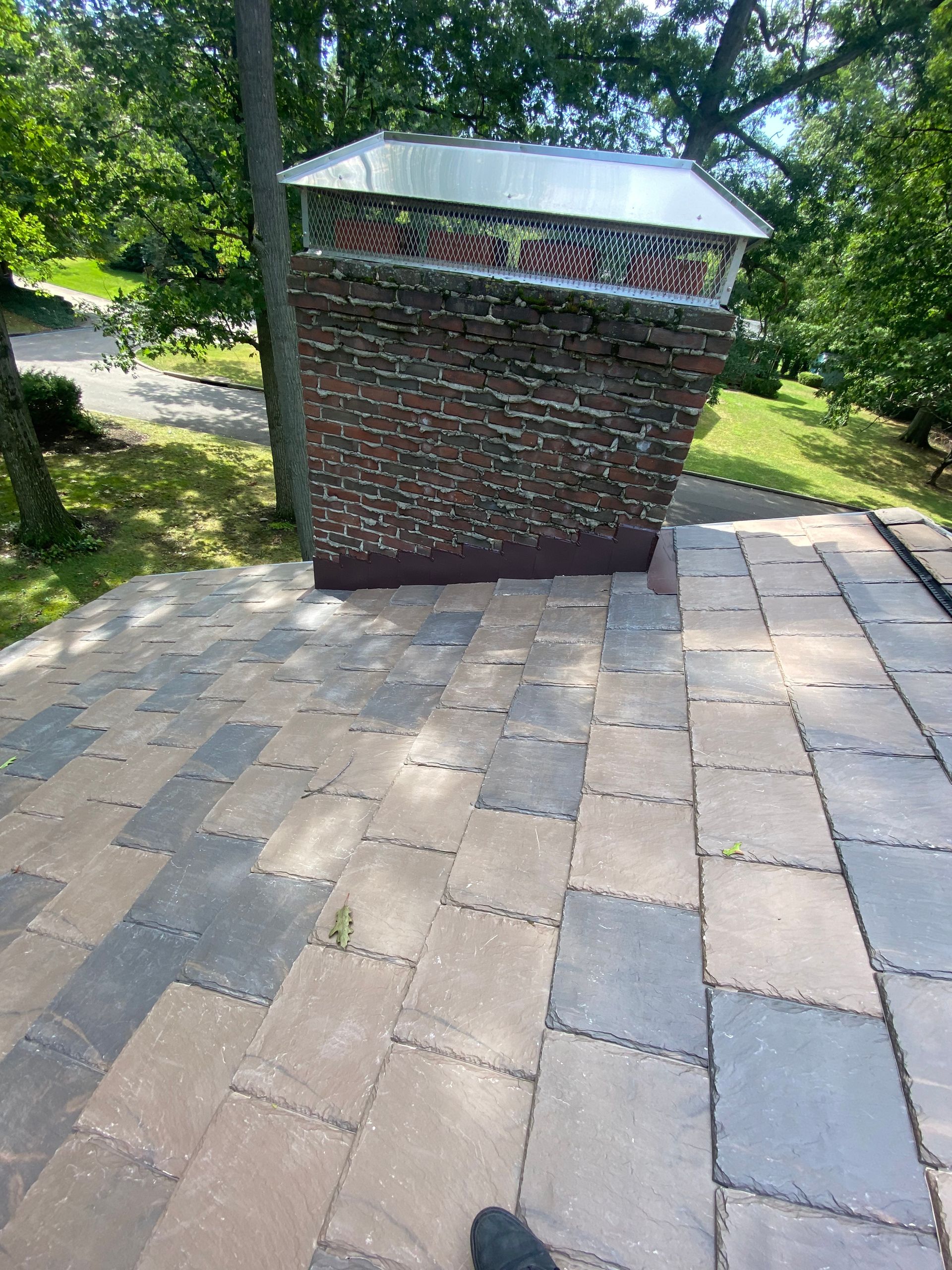 A brick chimney is sitting on top of a brick patio.