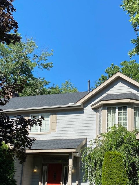 A house with a red door and a blue sky in the background