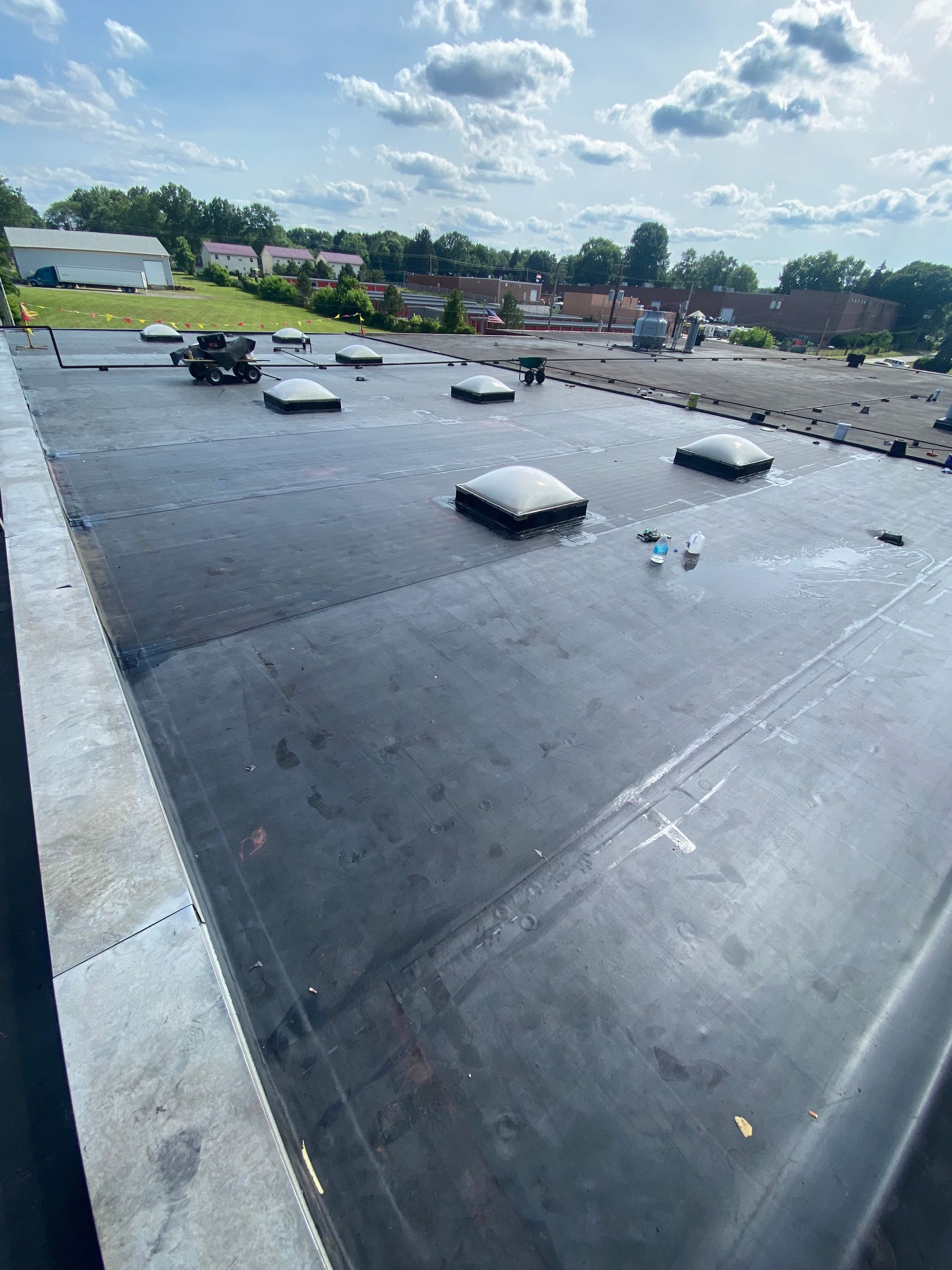A black roof with a lot of skylights on it.