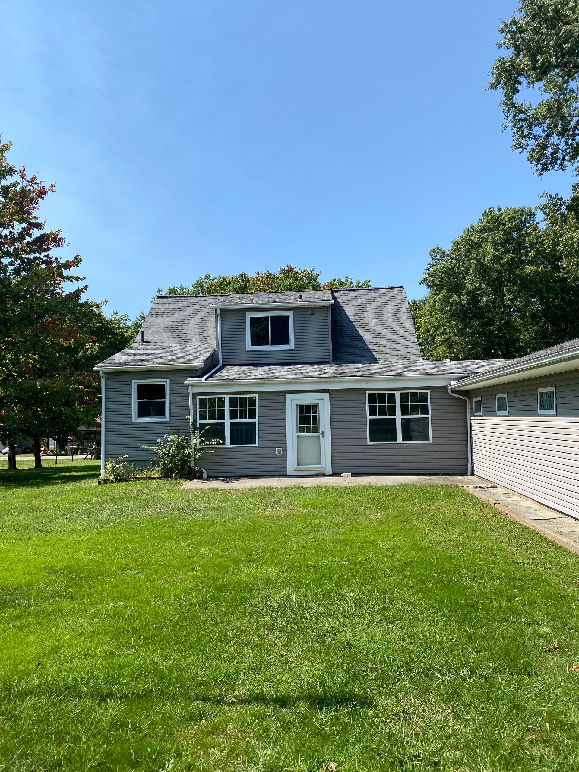 A house with a large lawn in front of it.