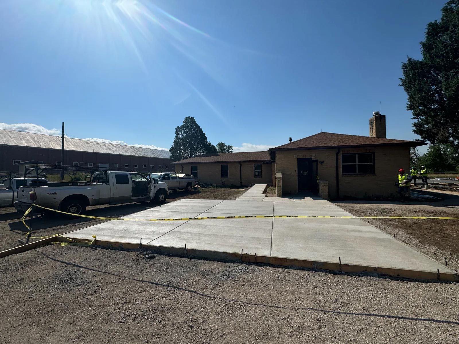 A white truck is parked in front of a house under construction.