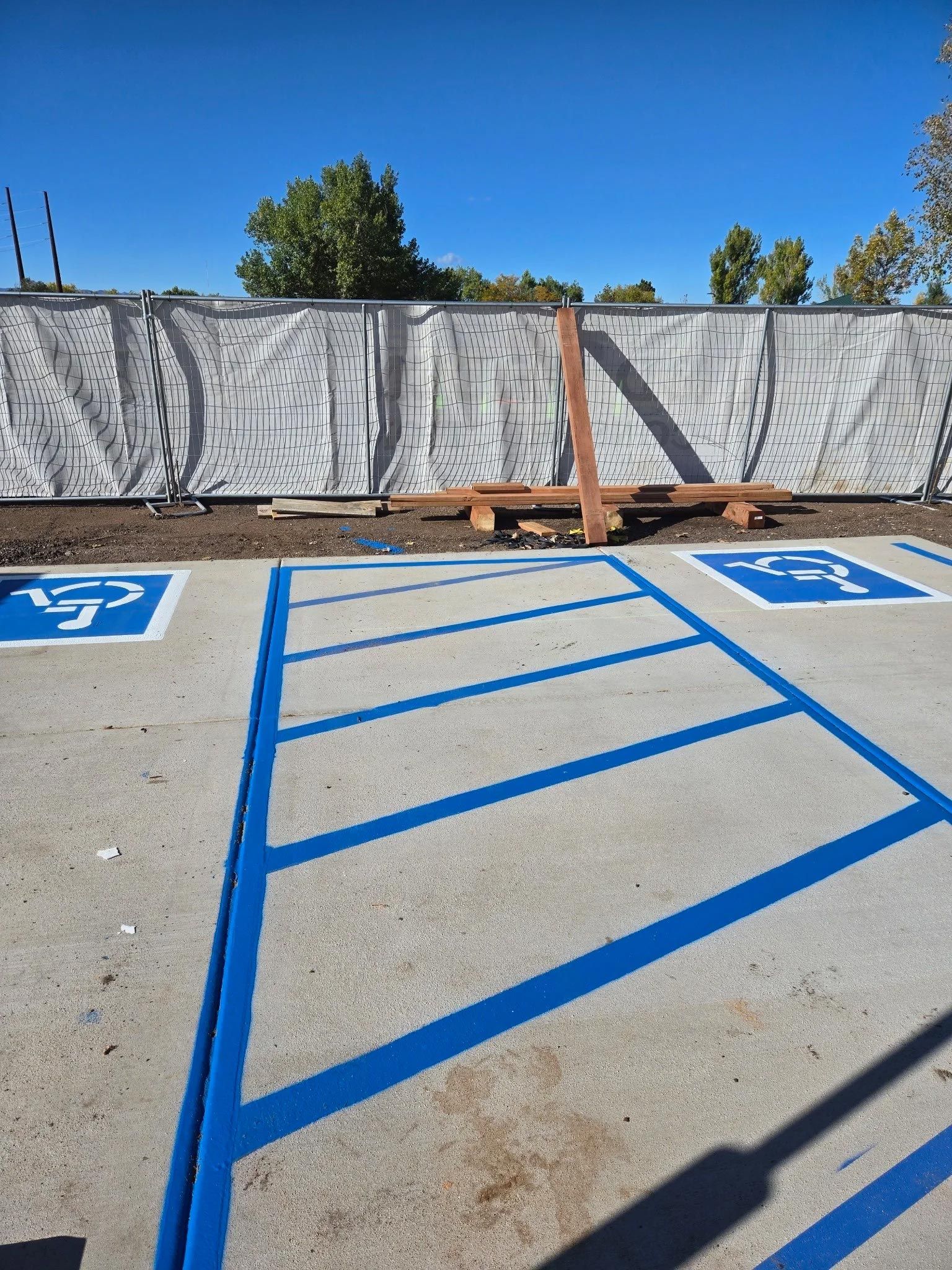 A handicapped parking spot with a fence in the background