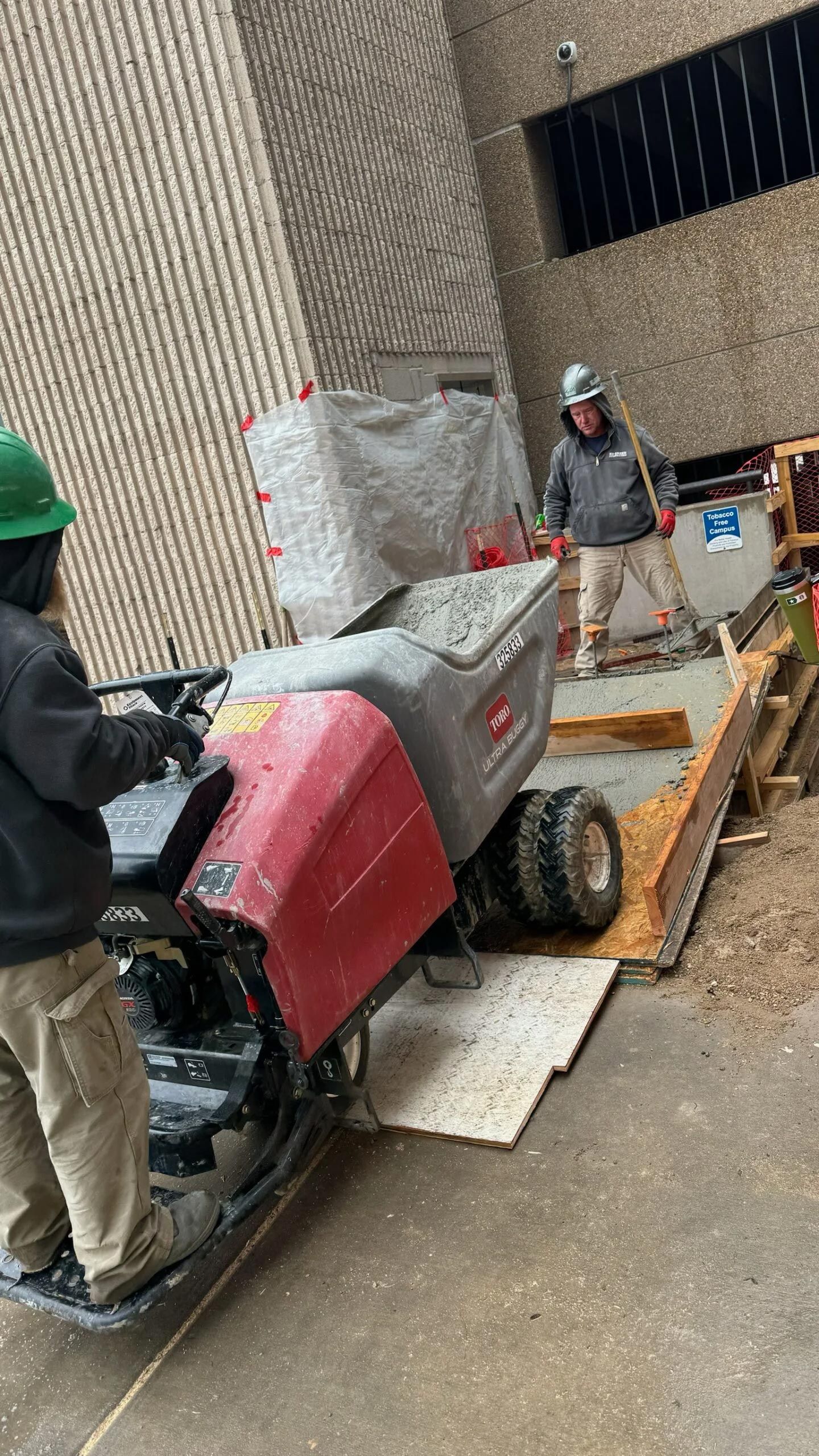 A man is driving a tractor on a construction site.