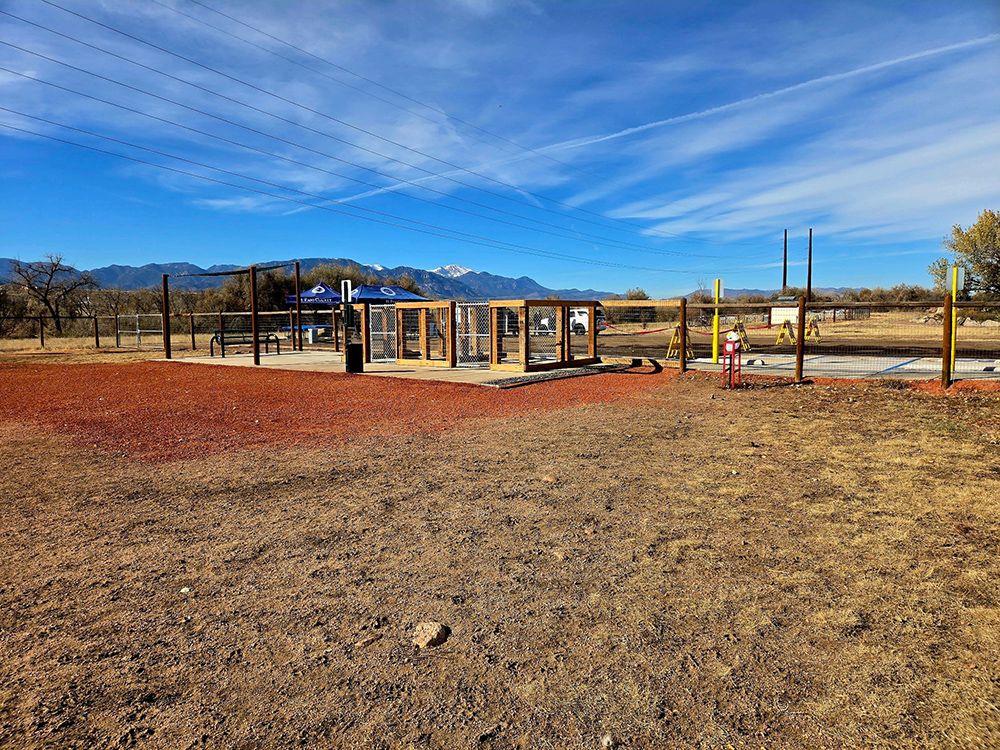 A playground is being built in a field with mountains in the background.