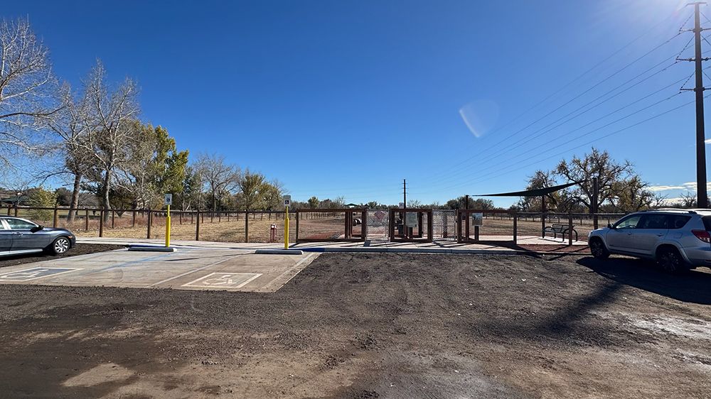 A car is parked in a parking lot next to a playground.