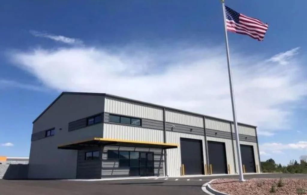 An american flag is flying in front of a large building.