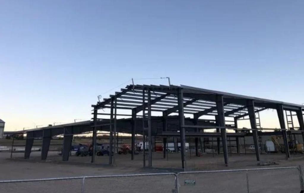 A large metal structure is being built in the desert.