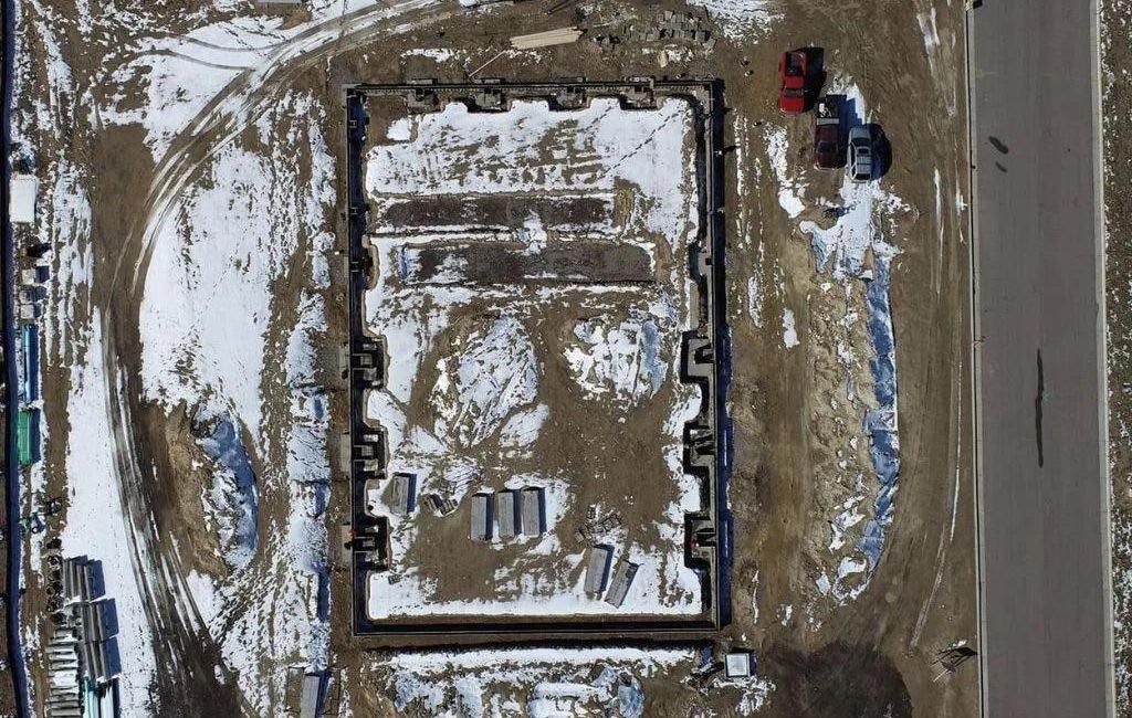An aerial view of a building under construction in the snow