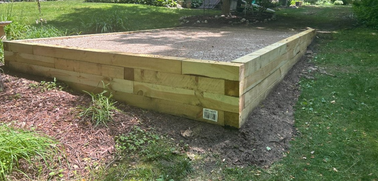 A wooden fence is sitting on top of a lush green field.