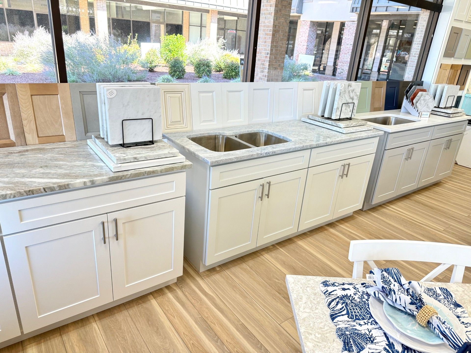 Kitchen cabinet displays with countertops, sinks, and samples in a showroom.