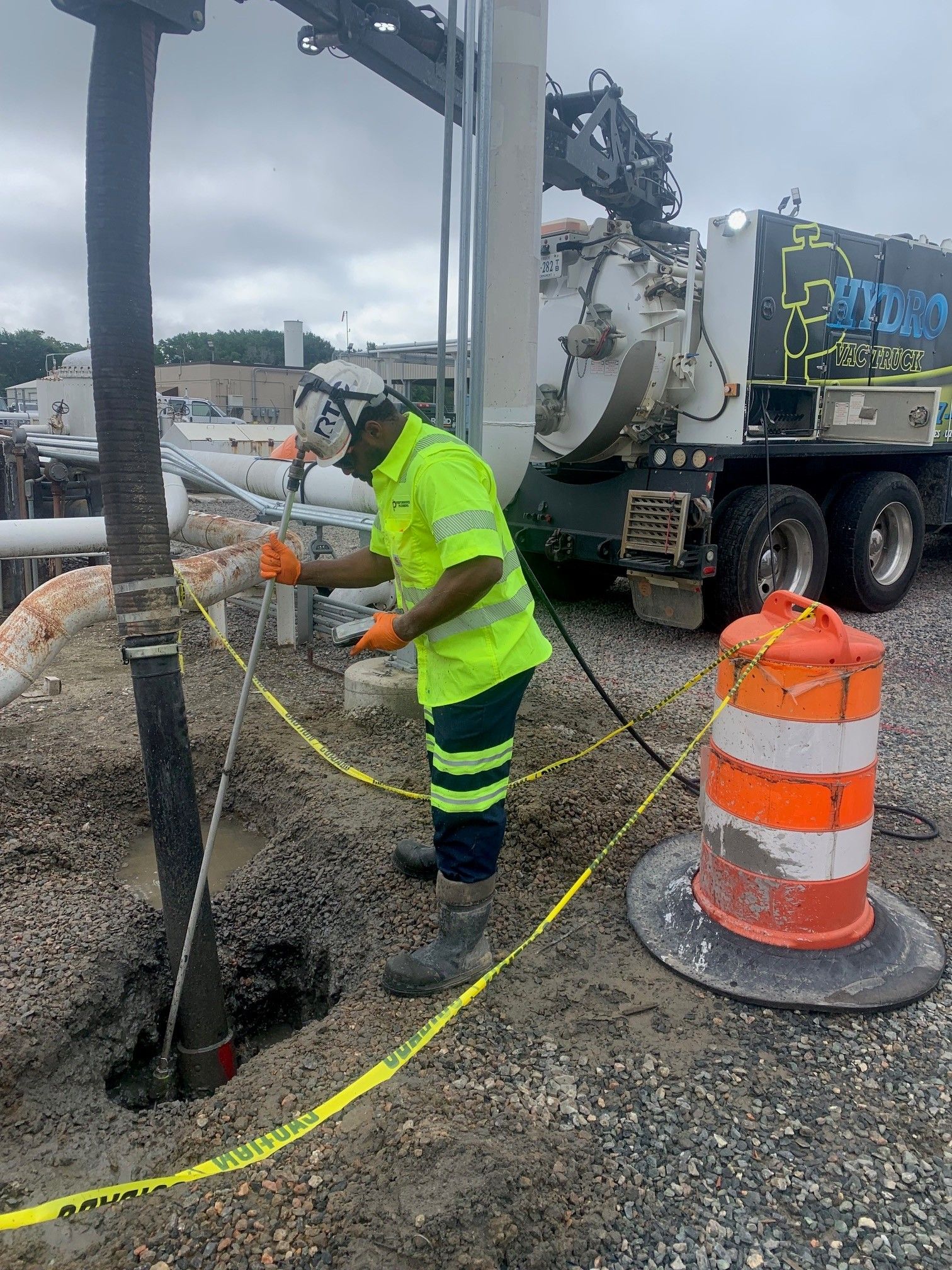 Worker in neon safety gear near utility truck at roadside construction site