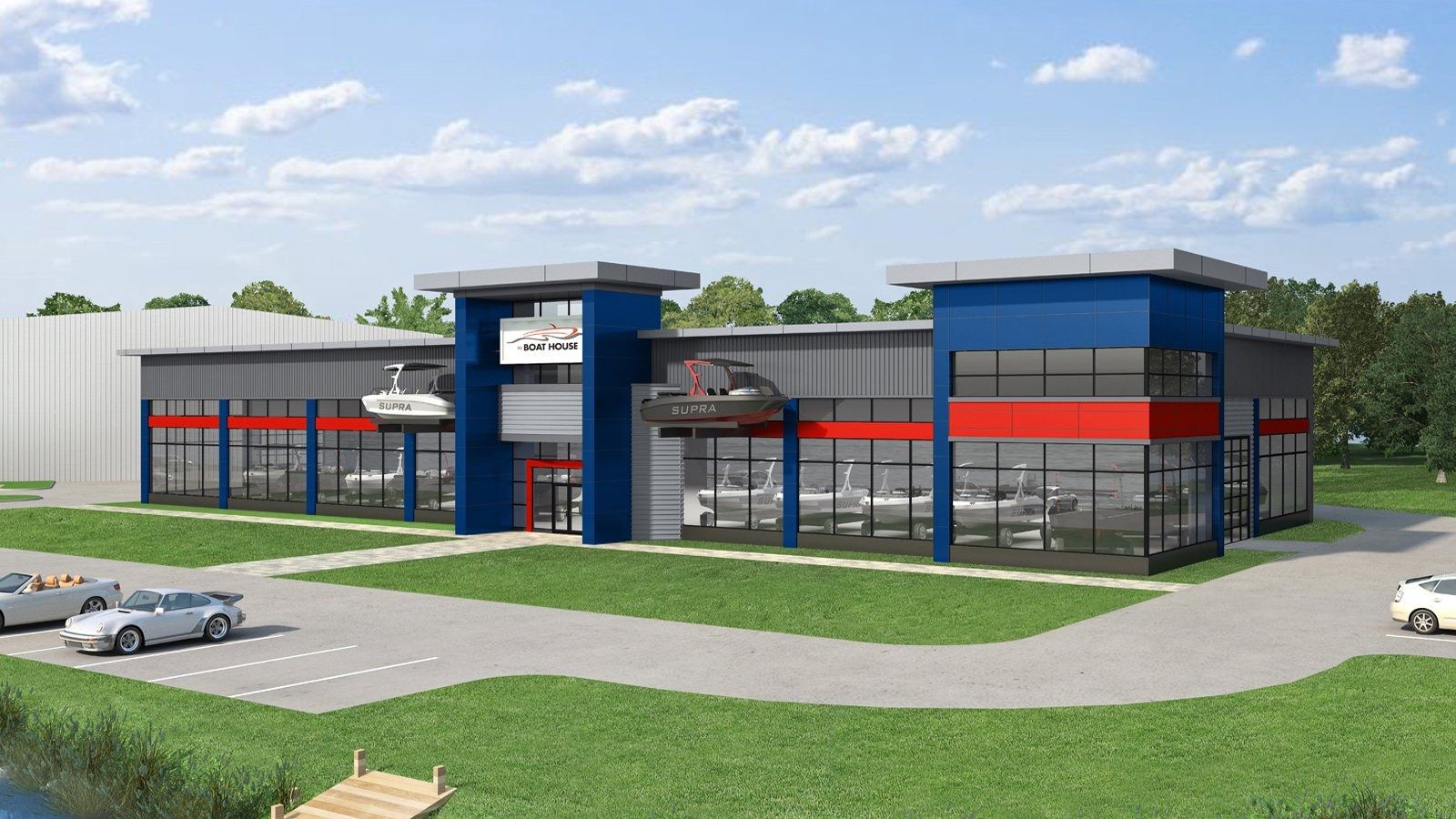 Modern commercial building with blue and red accents, glass front, and parking lot on a grassy lot