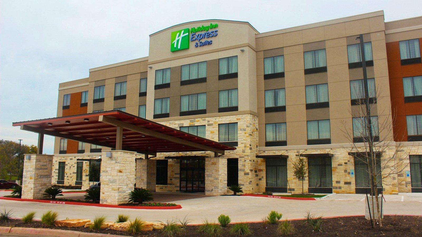 Exterior of a Holiday Inn Express hotel with stone facade and covered entrance