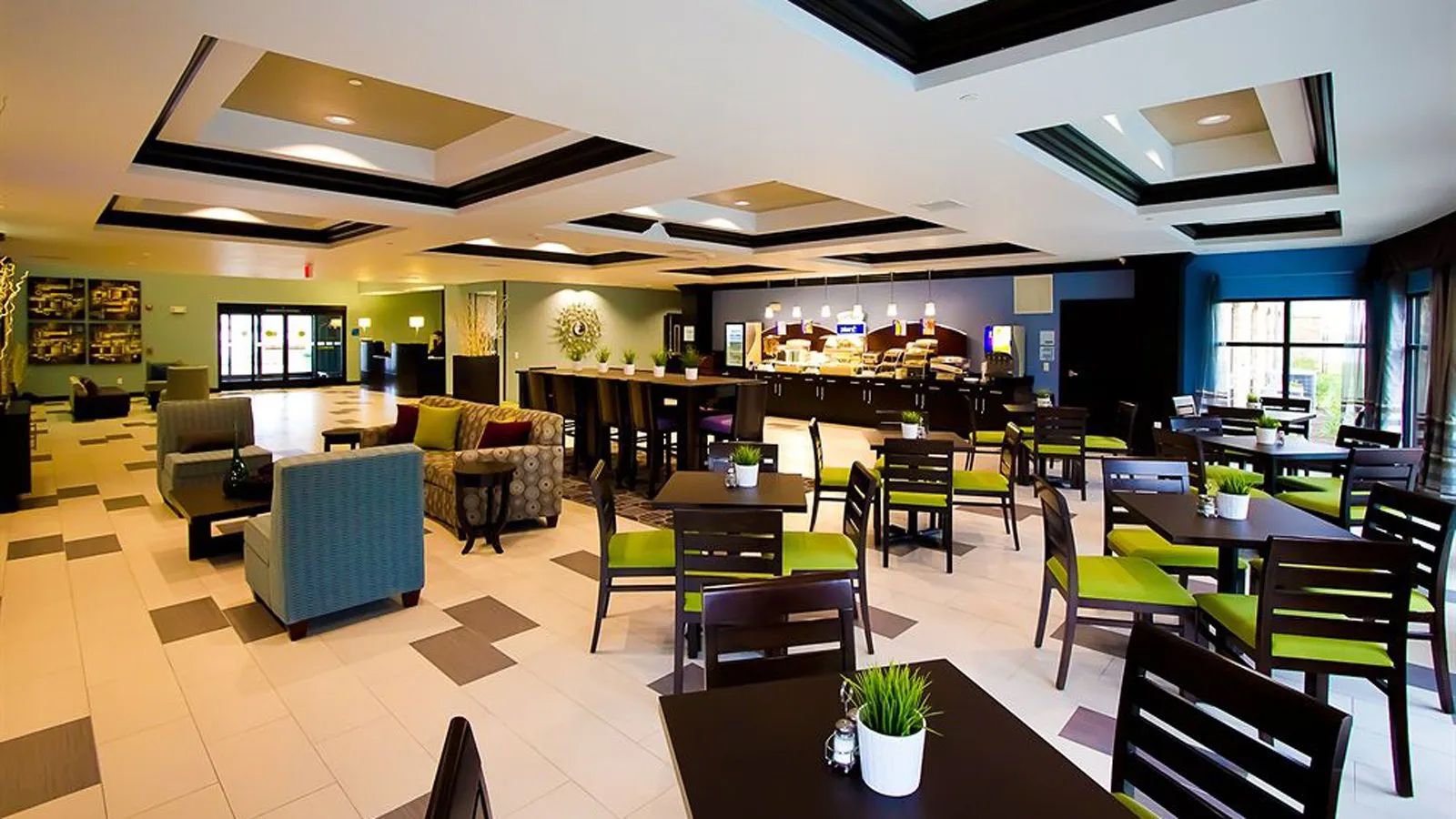 Modern restaurant dining area with tables, chairs, pendant lights, and a bar counter