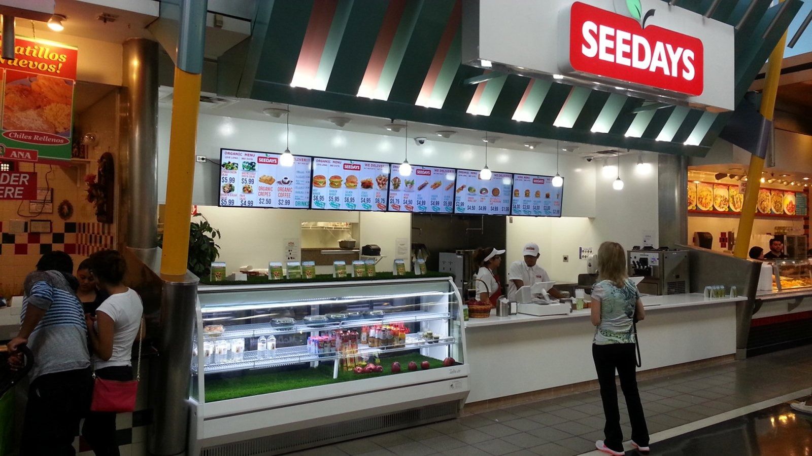 Seedays bakery counter in a shopping mall, with staff serving customers under bright menu signs