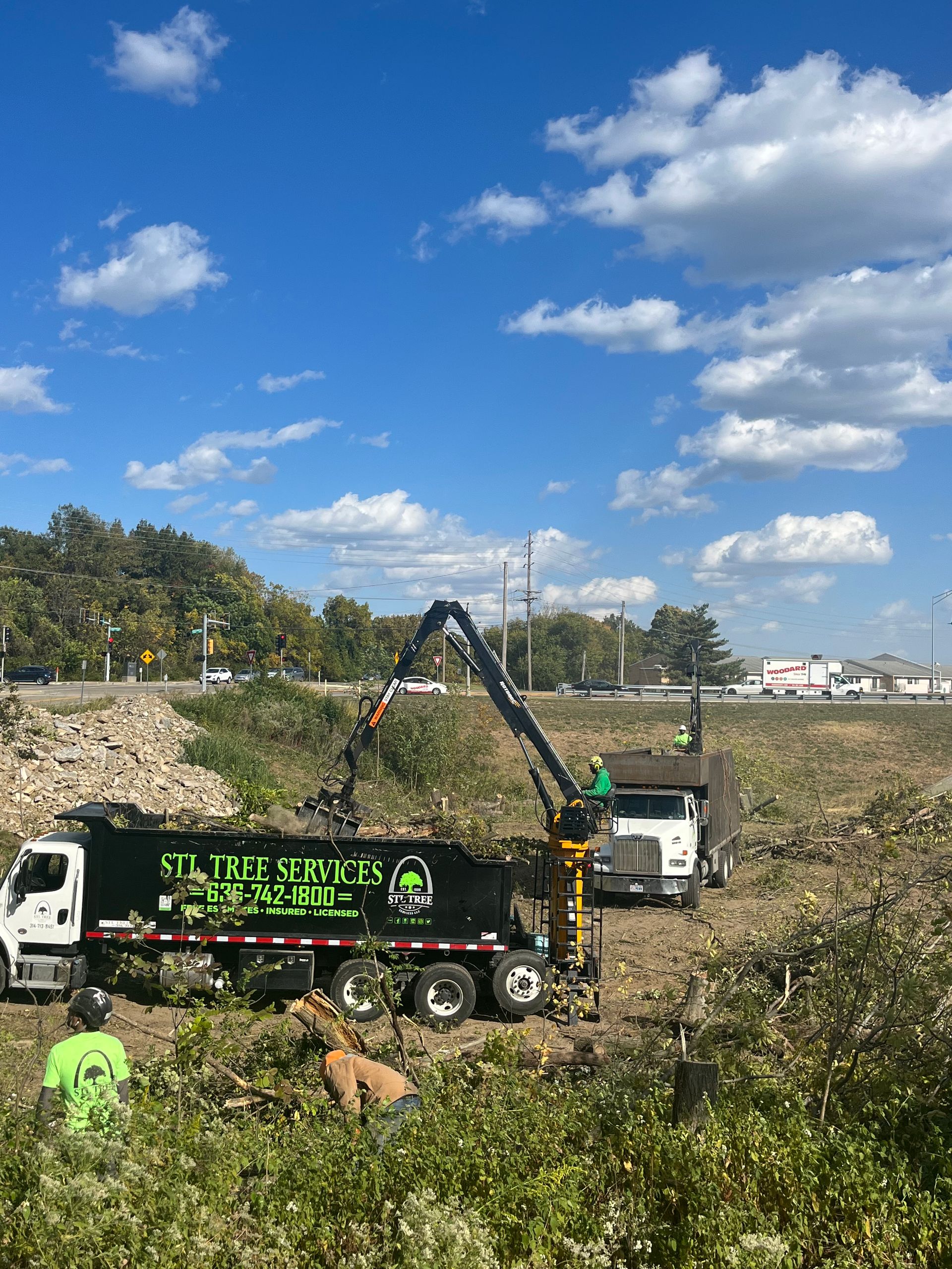 A truck with a crane attached to it is parked in a field.