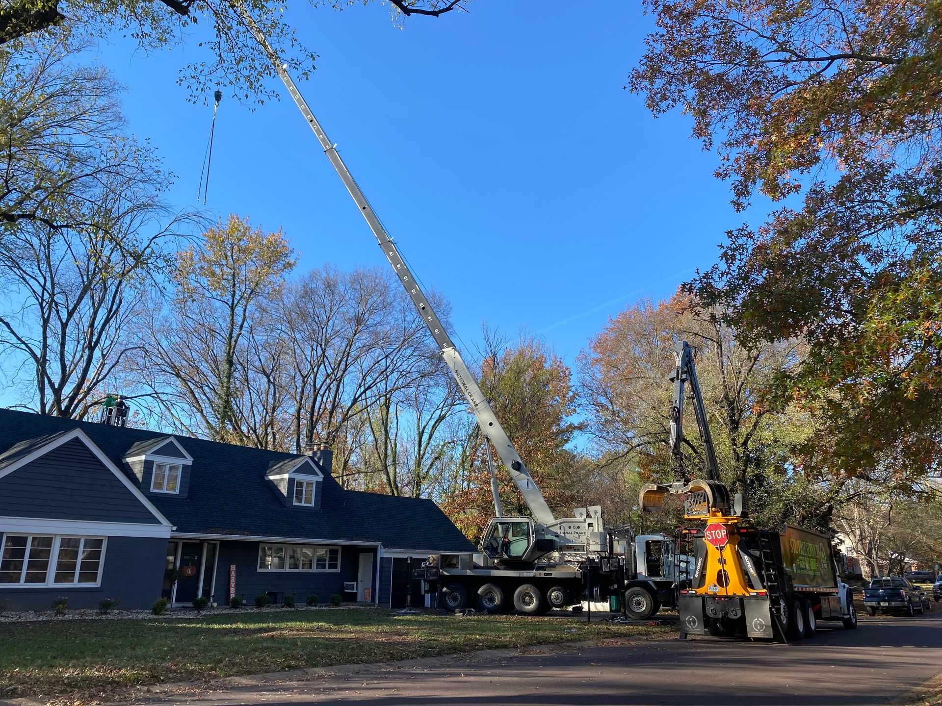 A large crane is sitting in front of a house.