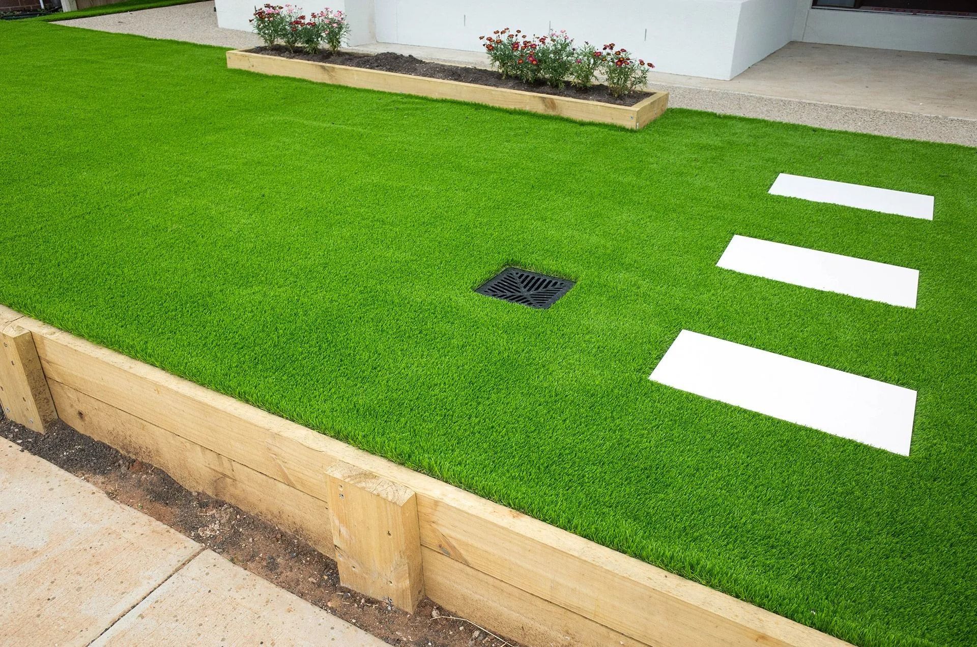 Green artificial turf yard with a small square drain 