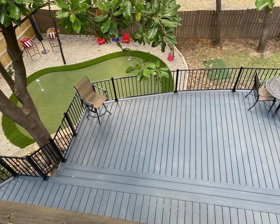 Rooftop deck overlooking a garden with patio chairs and black railings