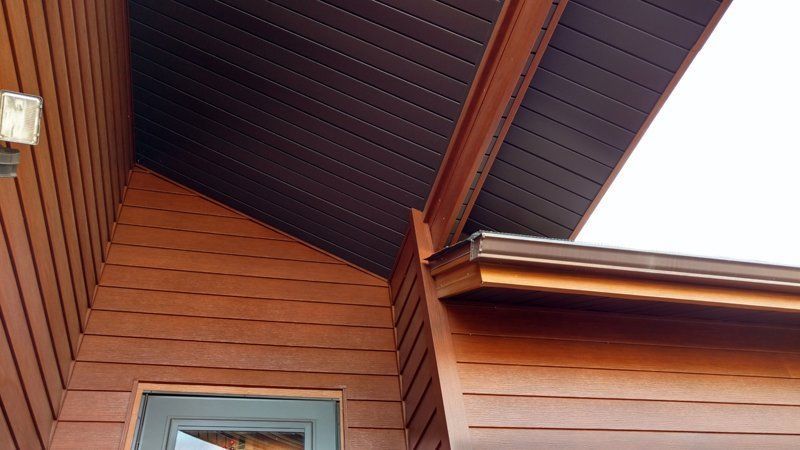 Brown house exterior with dark brown siding and overhang.