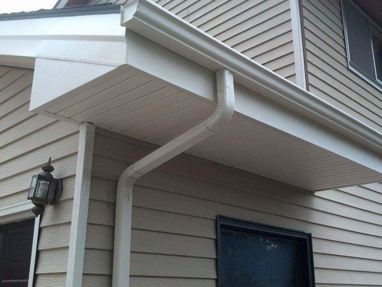 Beige house exterior with a white overhang, gutter, and downspout.