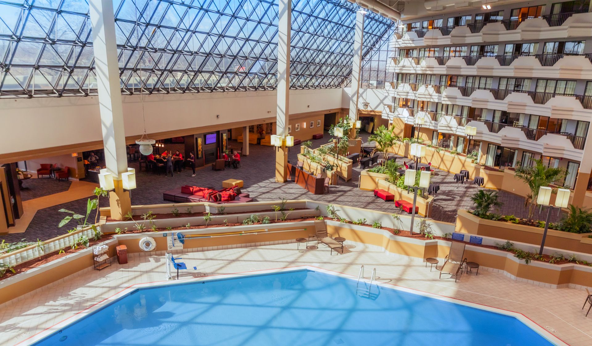 There is a large swimming pool in the middle of a large building.