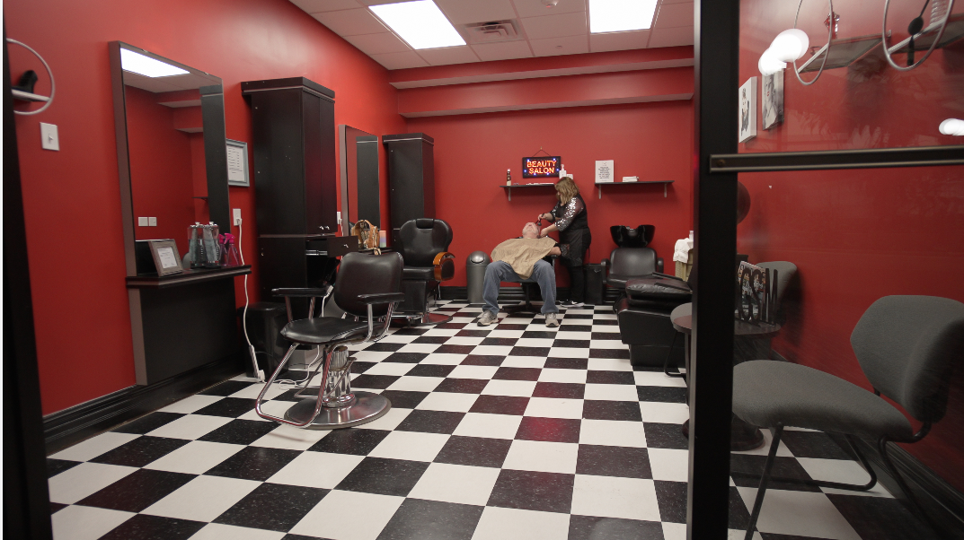 A man is getting his hair cut in a barber shop