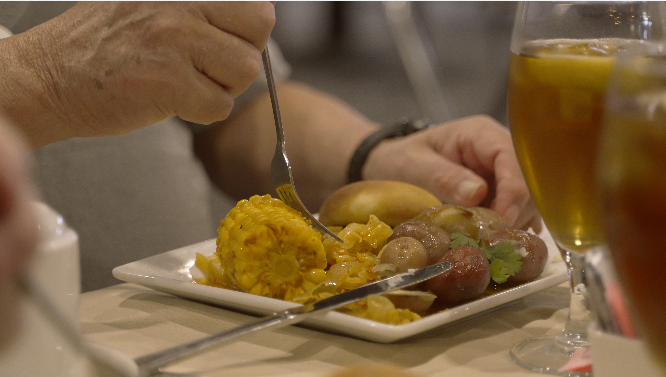 A person is eating a plate of food with a fork.