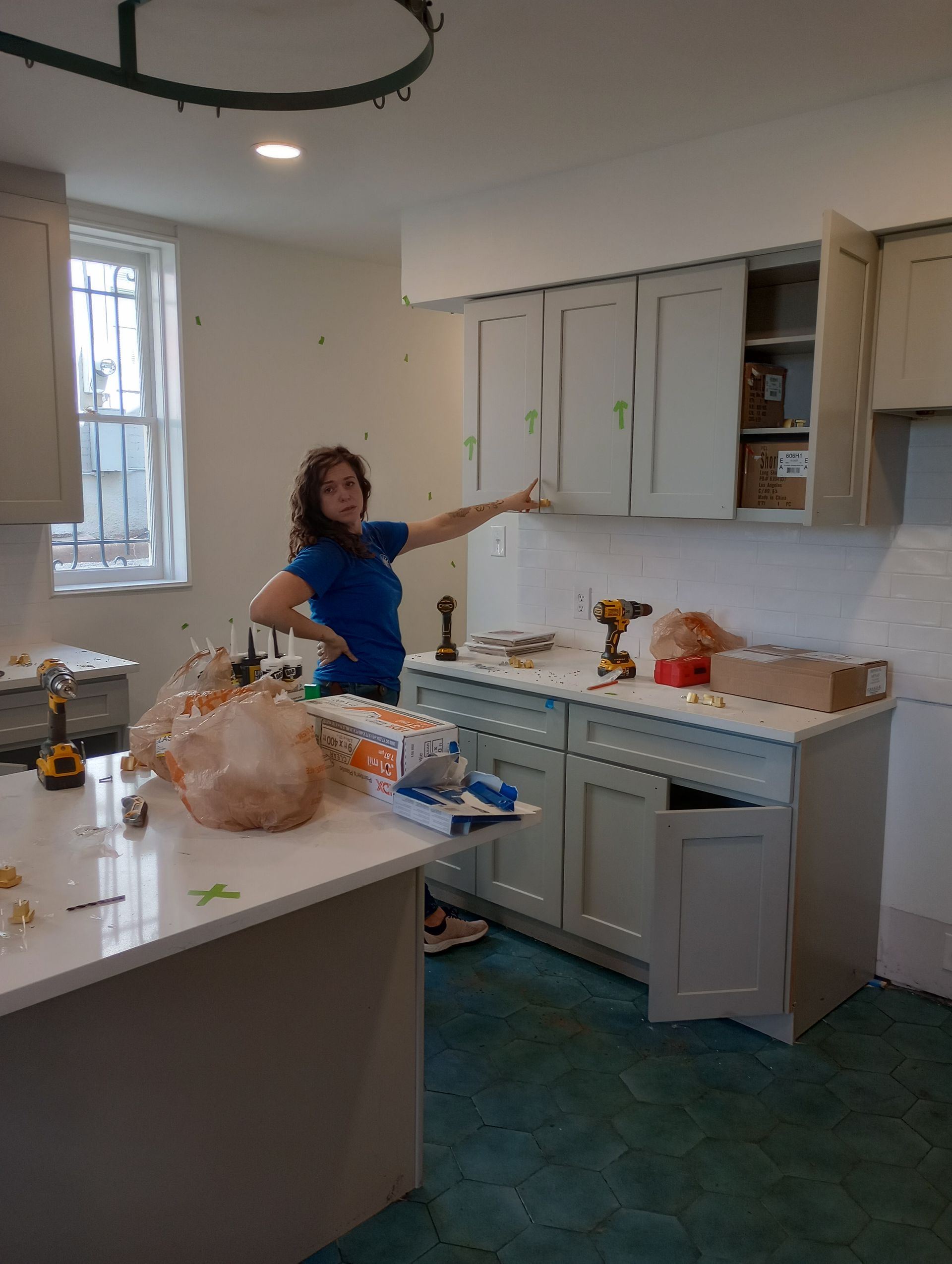 A woman is standing in a kitchen with a turkey on the counter.