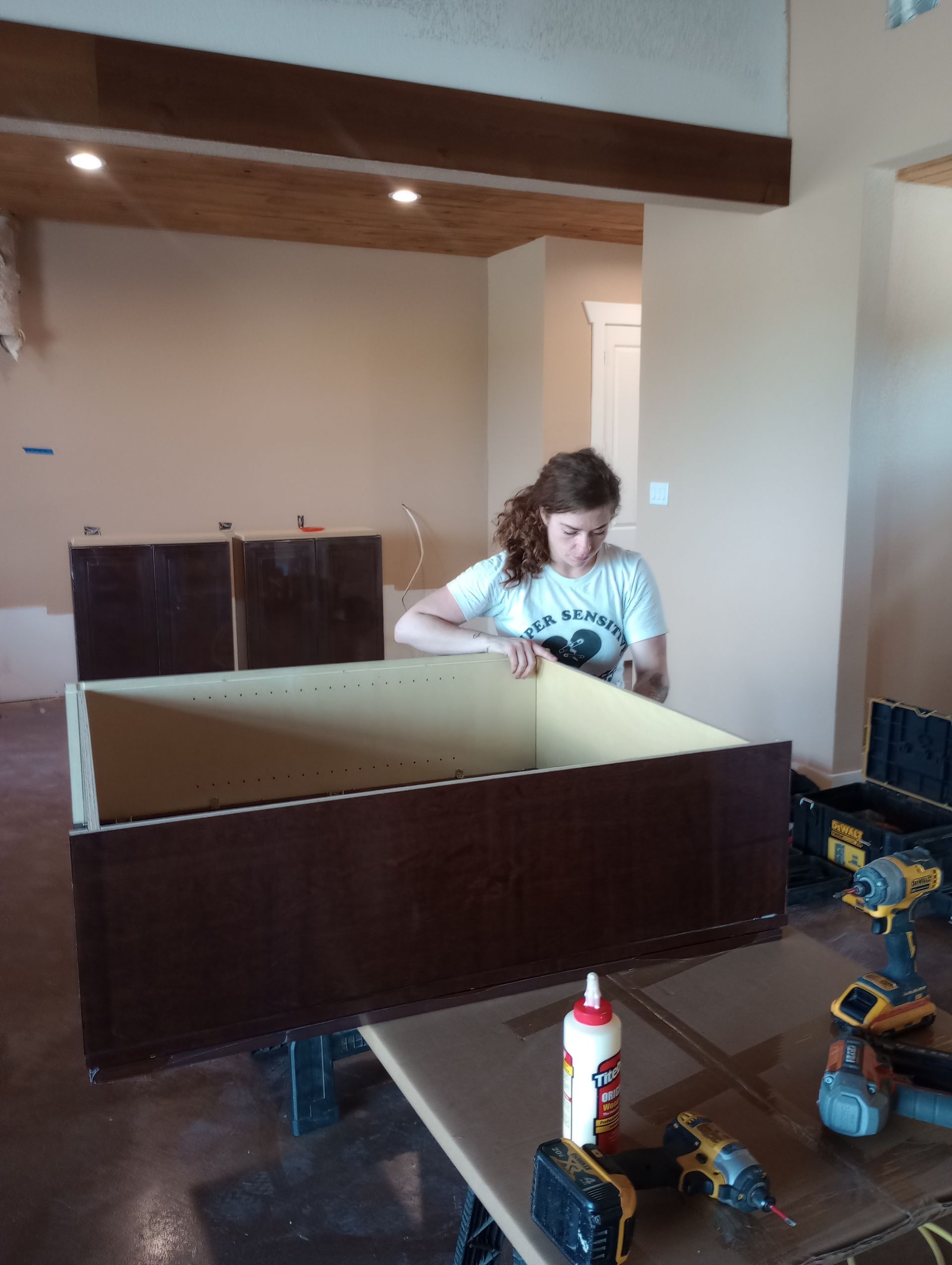 A woman is working on a piece of wood in a room.