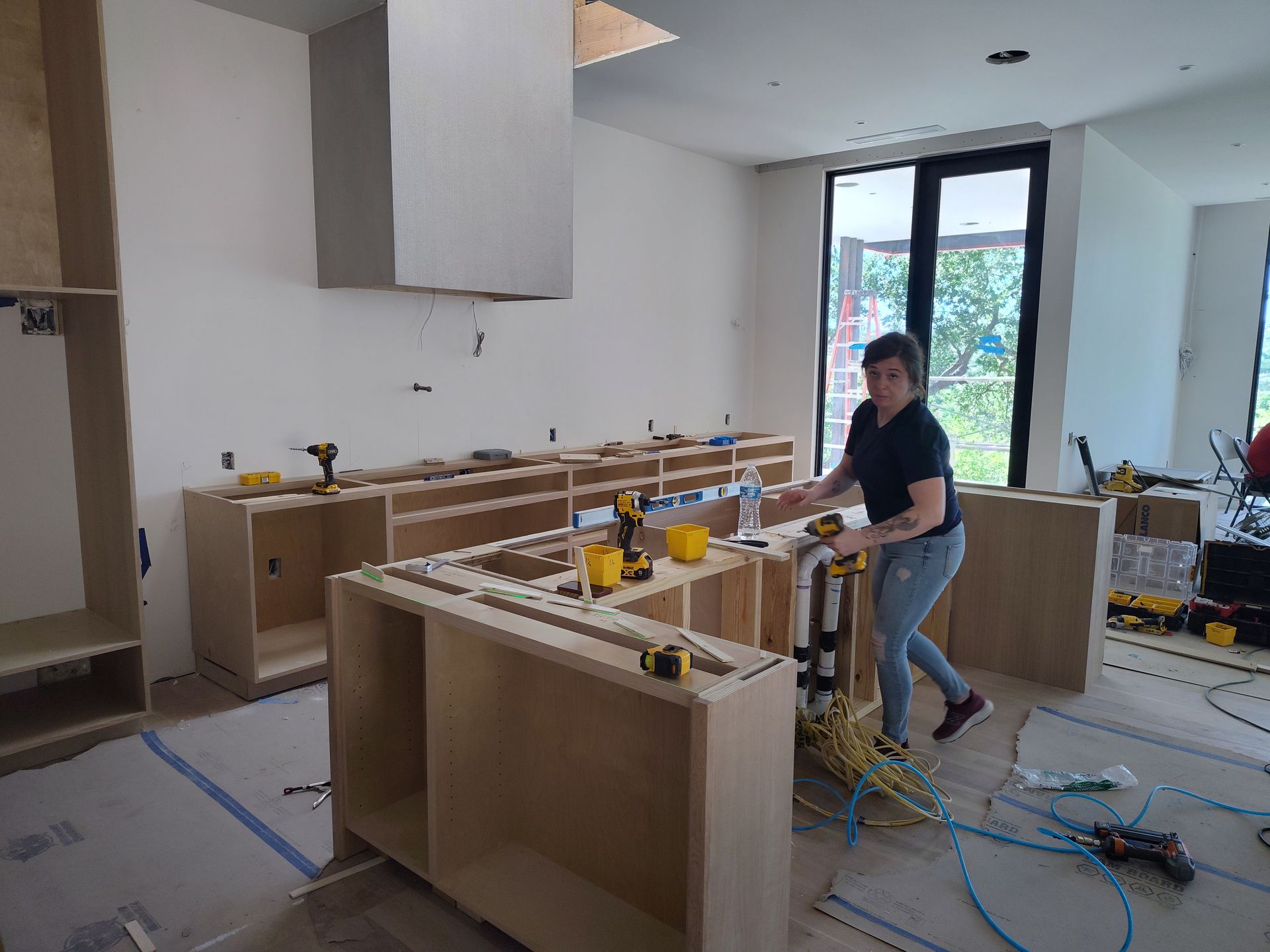 A man is working on a kitchen in a house under construction.