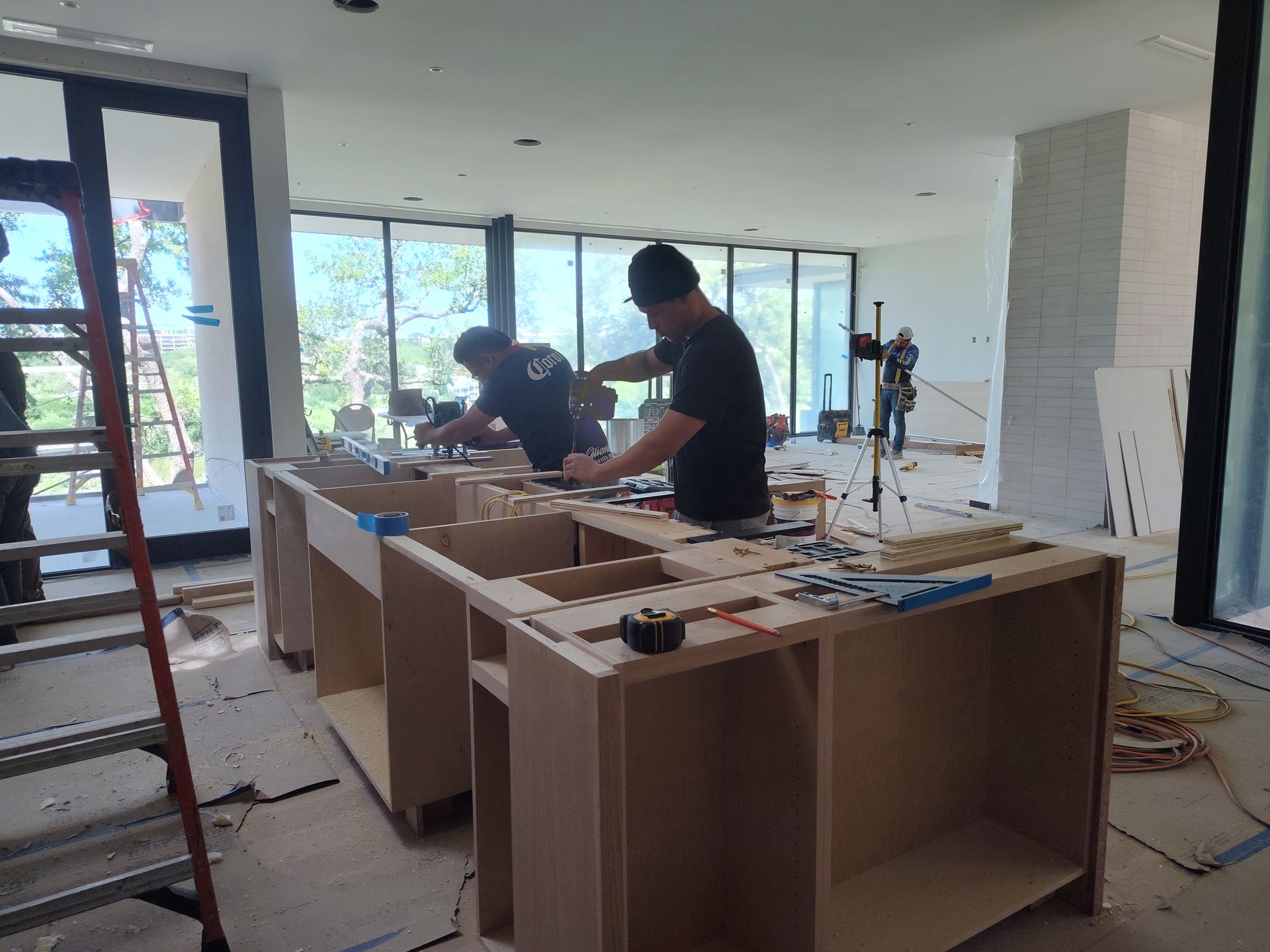 Two men are working on a wooden table in a room.
