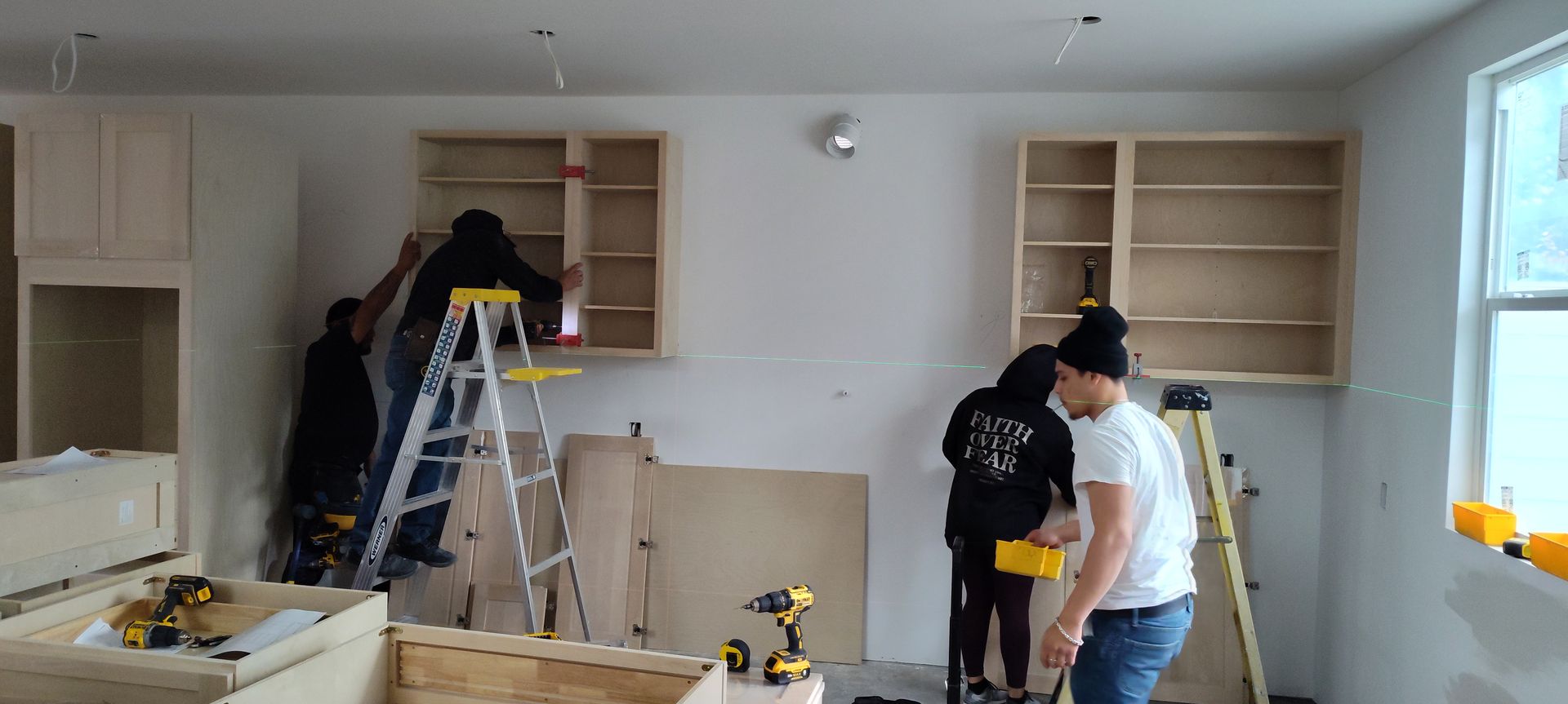 A group of people are working on a kitchen.