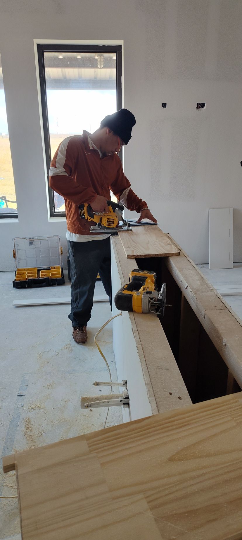 A man is cutting a piece of wood with a saw.