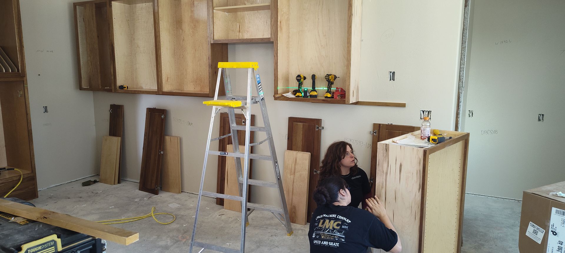A man and a woman are working on a kitchen.