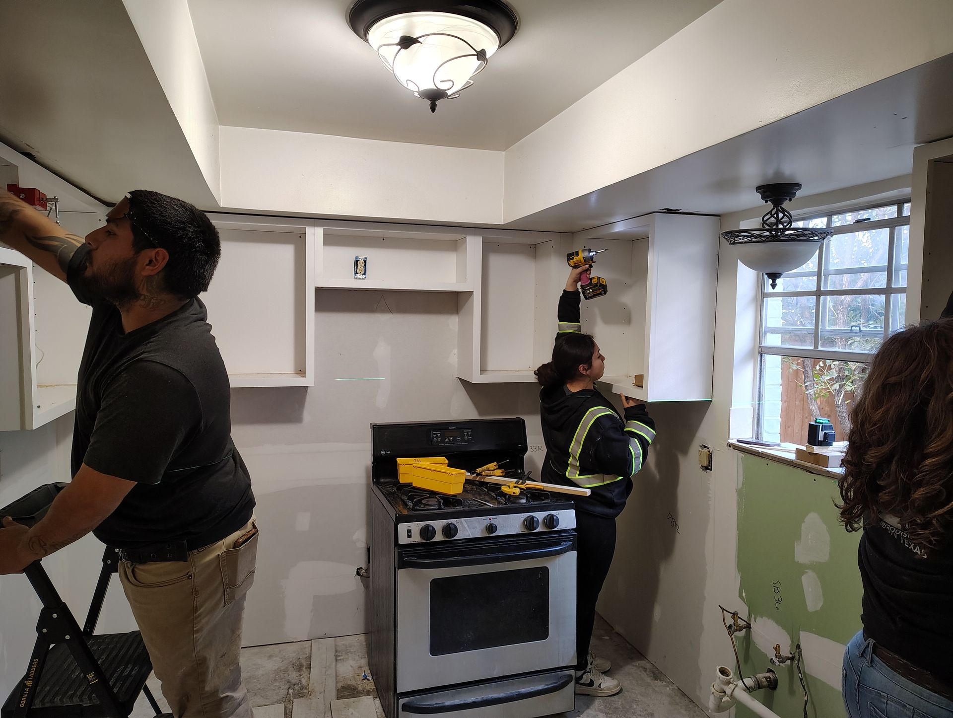 A group of people are working on a kitchen remodel.