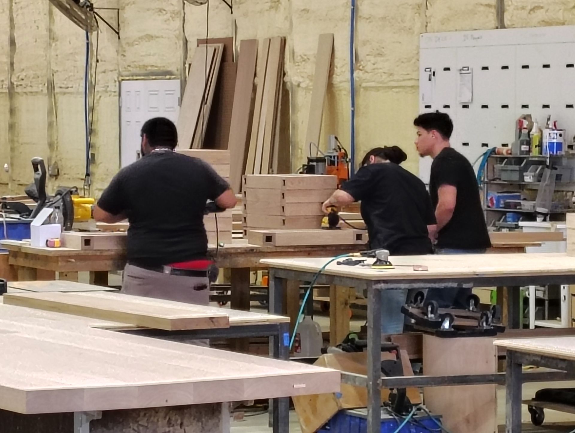 A group of men are working in a woodworking shop.