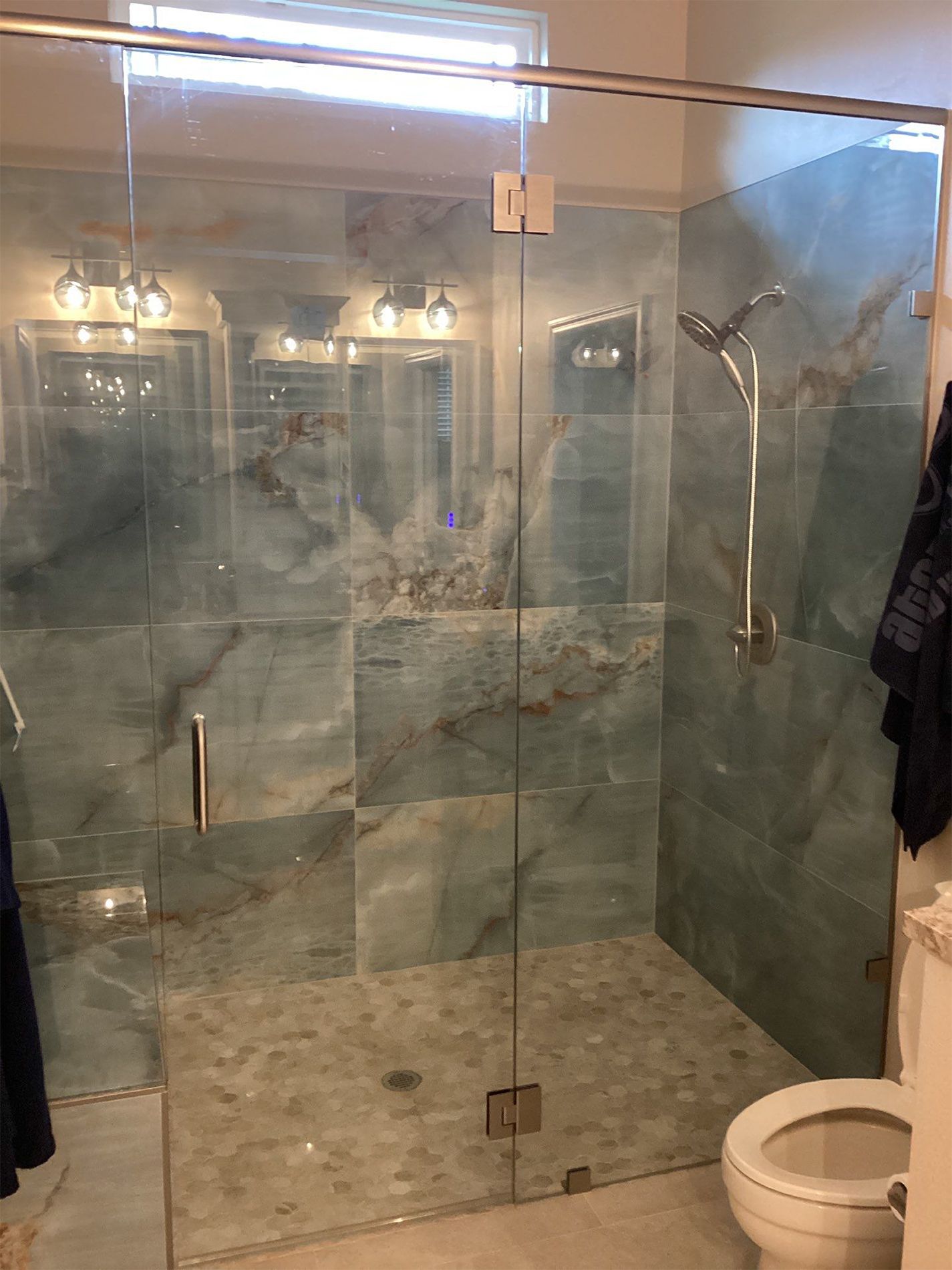 A bathroom with a walk in shower and a toilet.