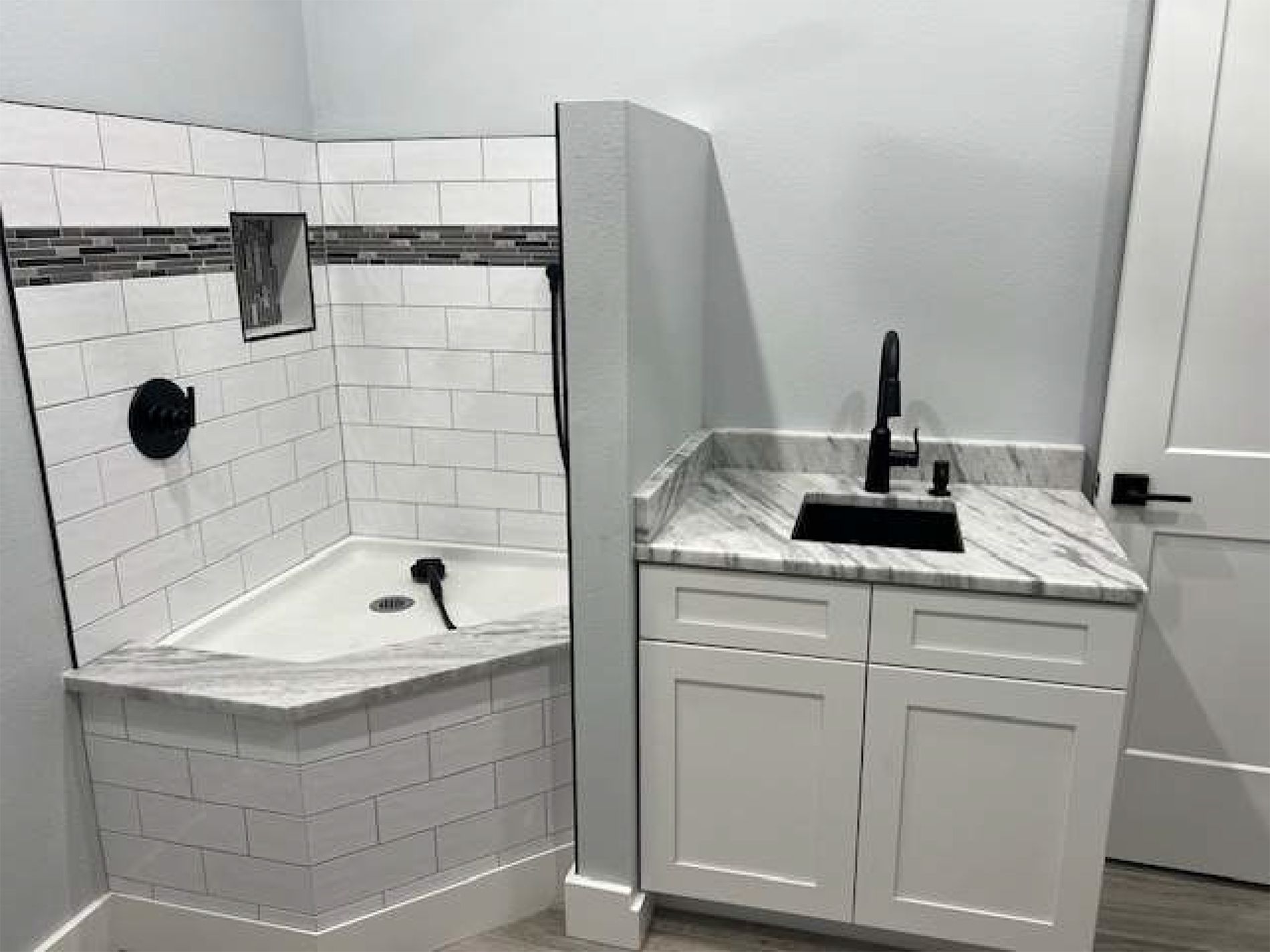 A bathroom with a tub , sink , and shower.