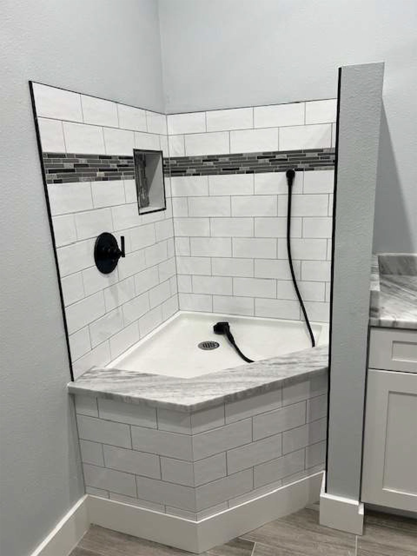 A bathroom with a bathtub in the corner and a shower.
