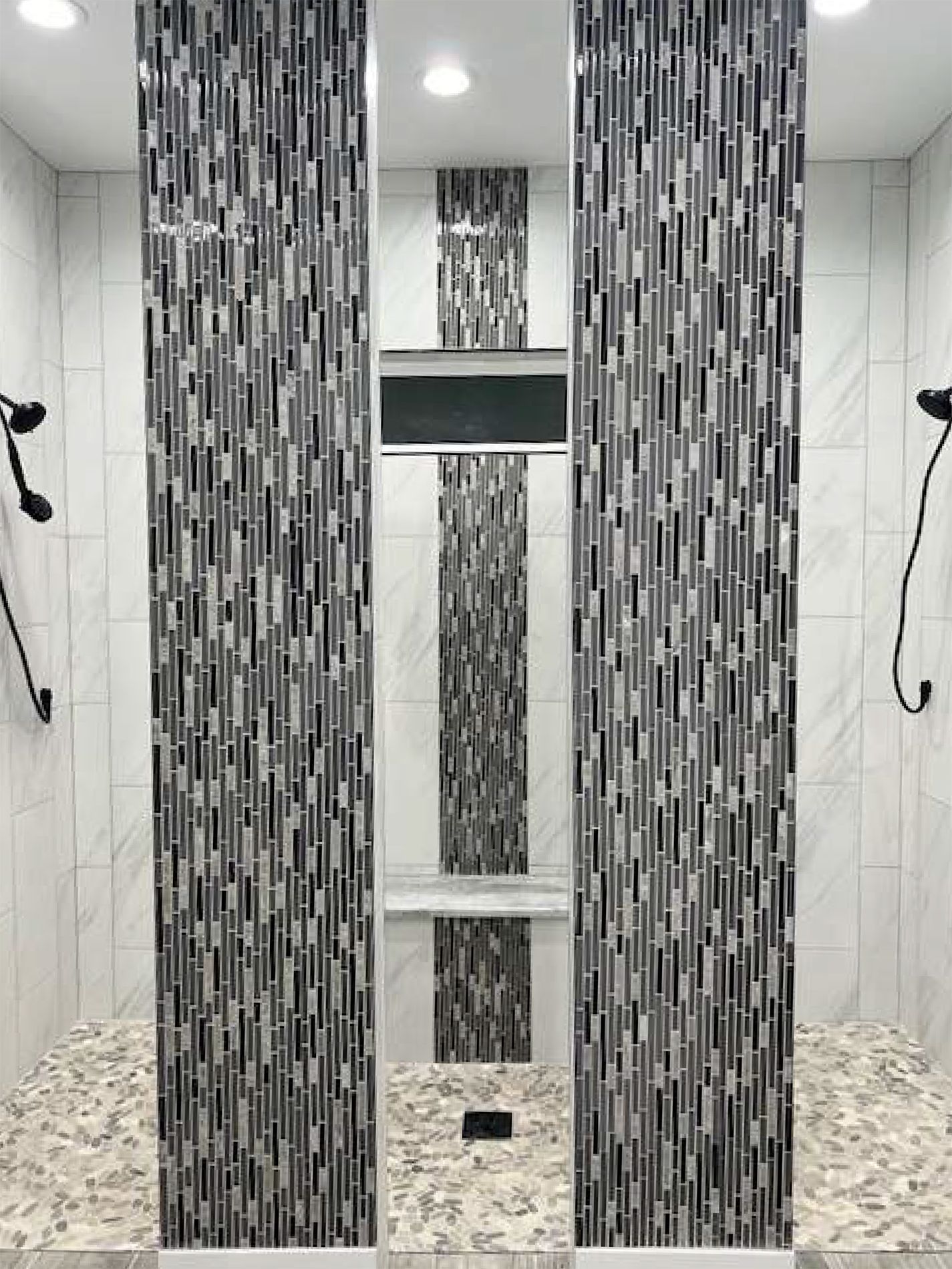 A bathroom with a walk in shower and two shower heads.