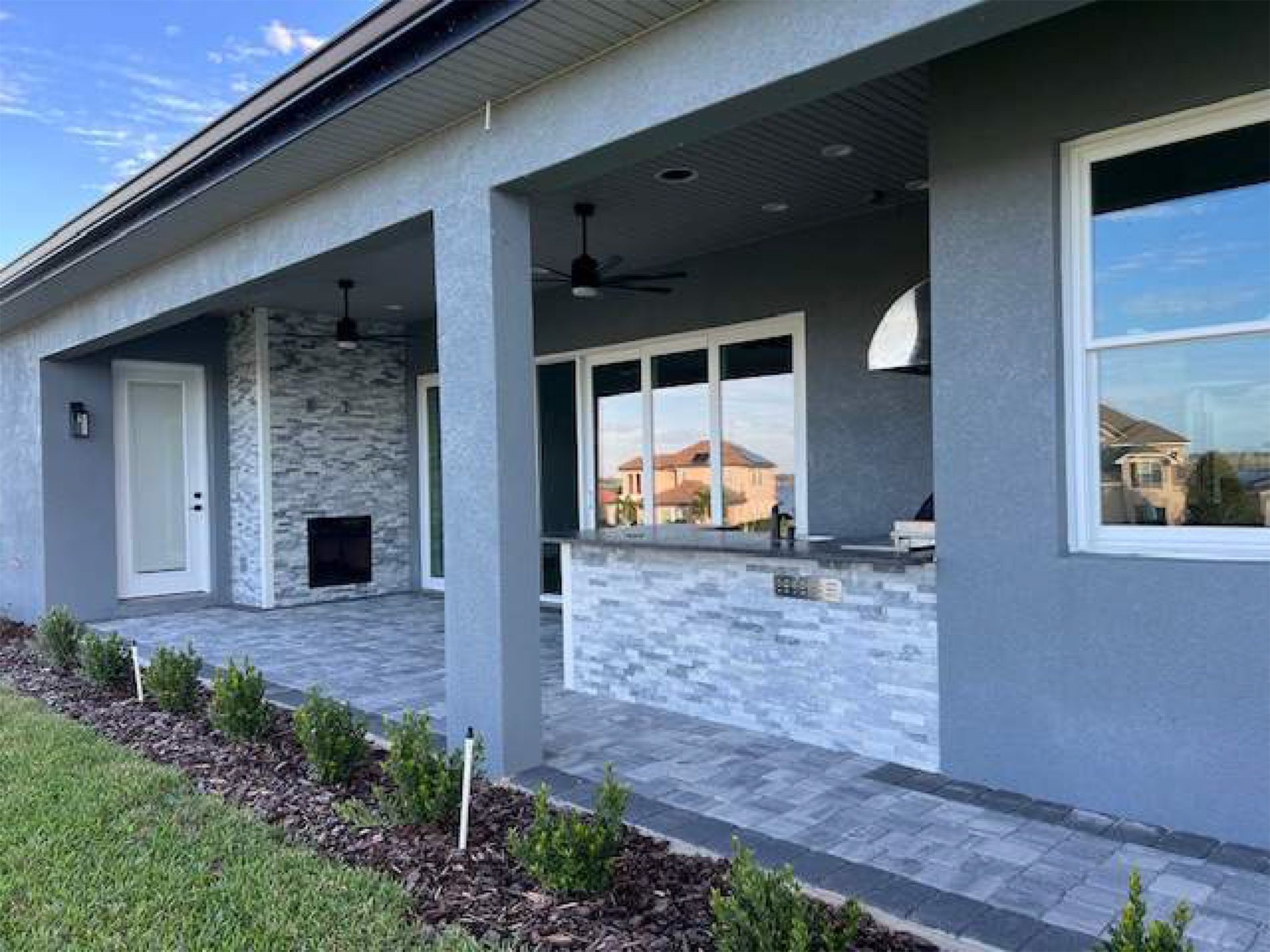 A house with a covered patio and a kitchen in the backyard.