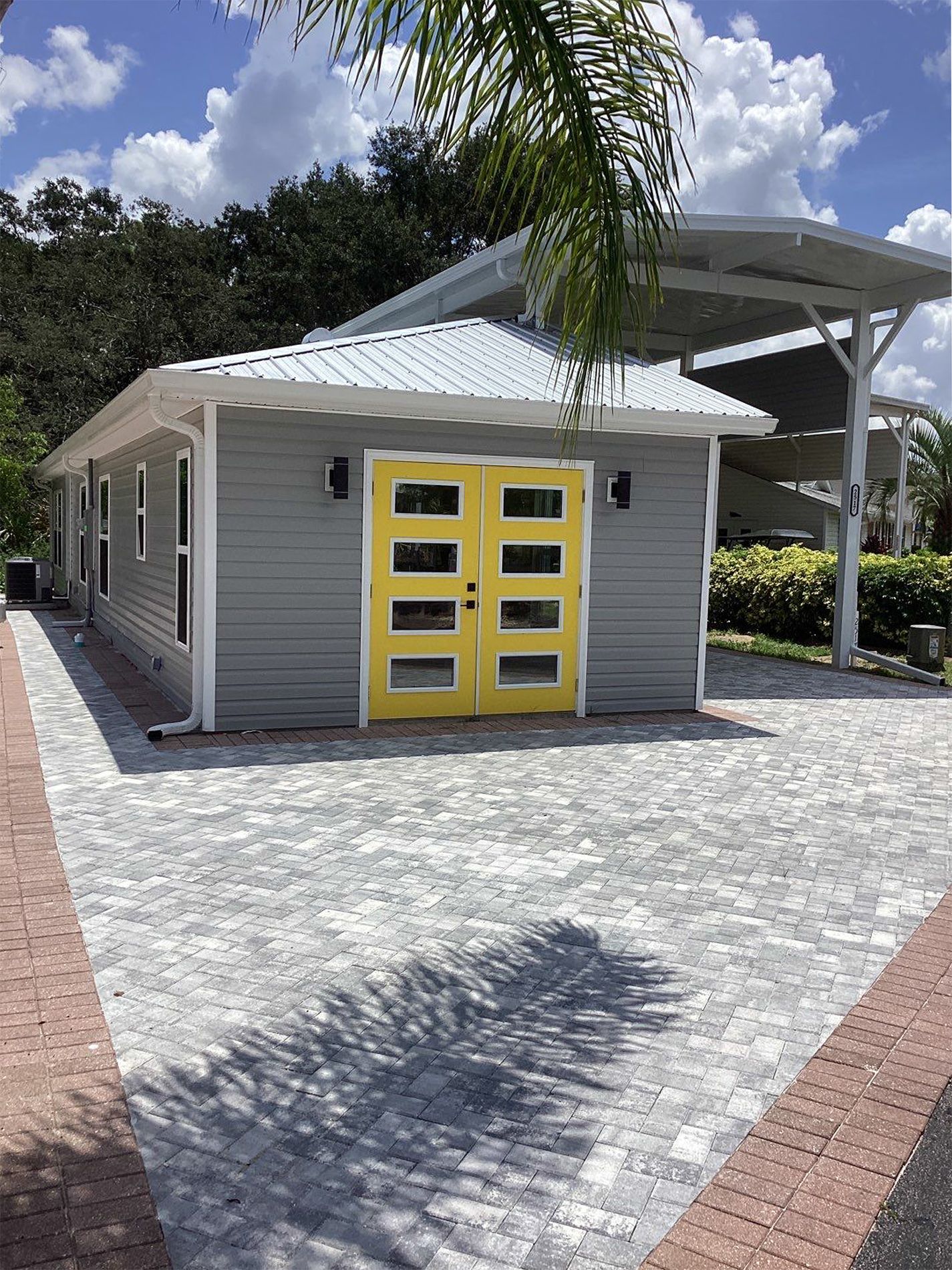A house with a yellow garage door and a carport.