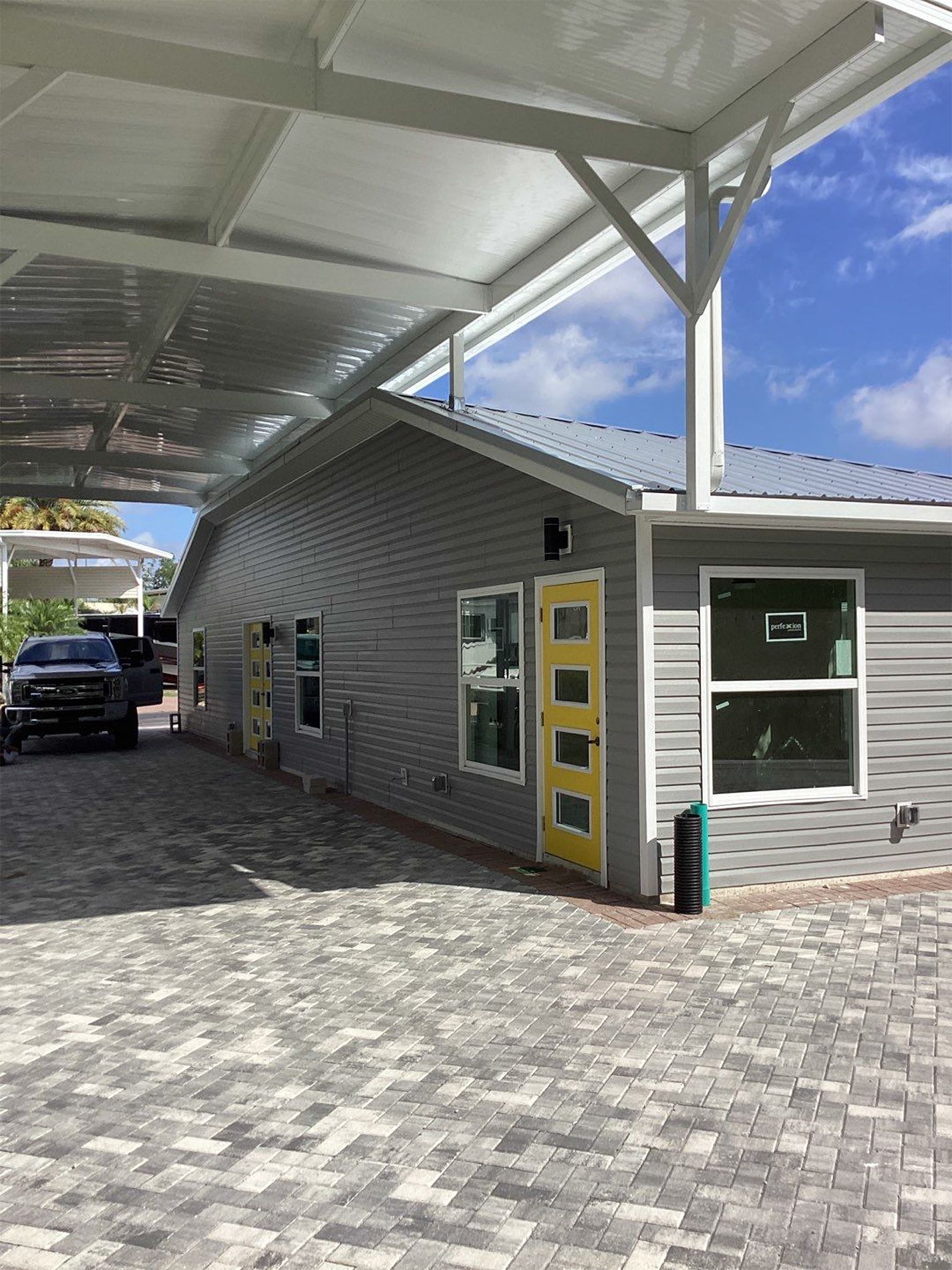 A car is parked in front of a house with a yellow door.