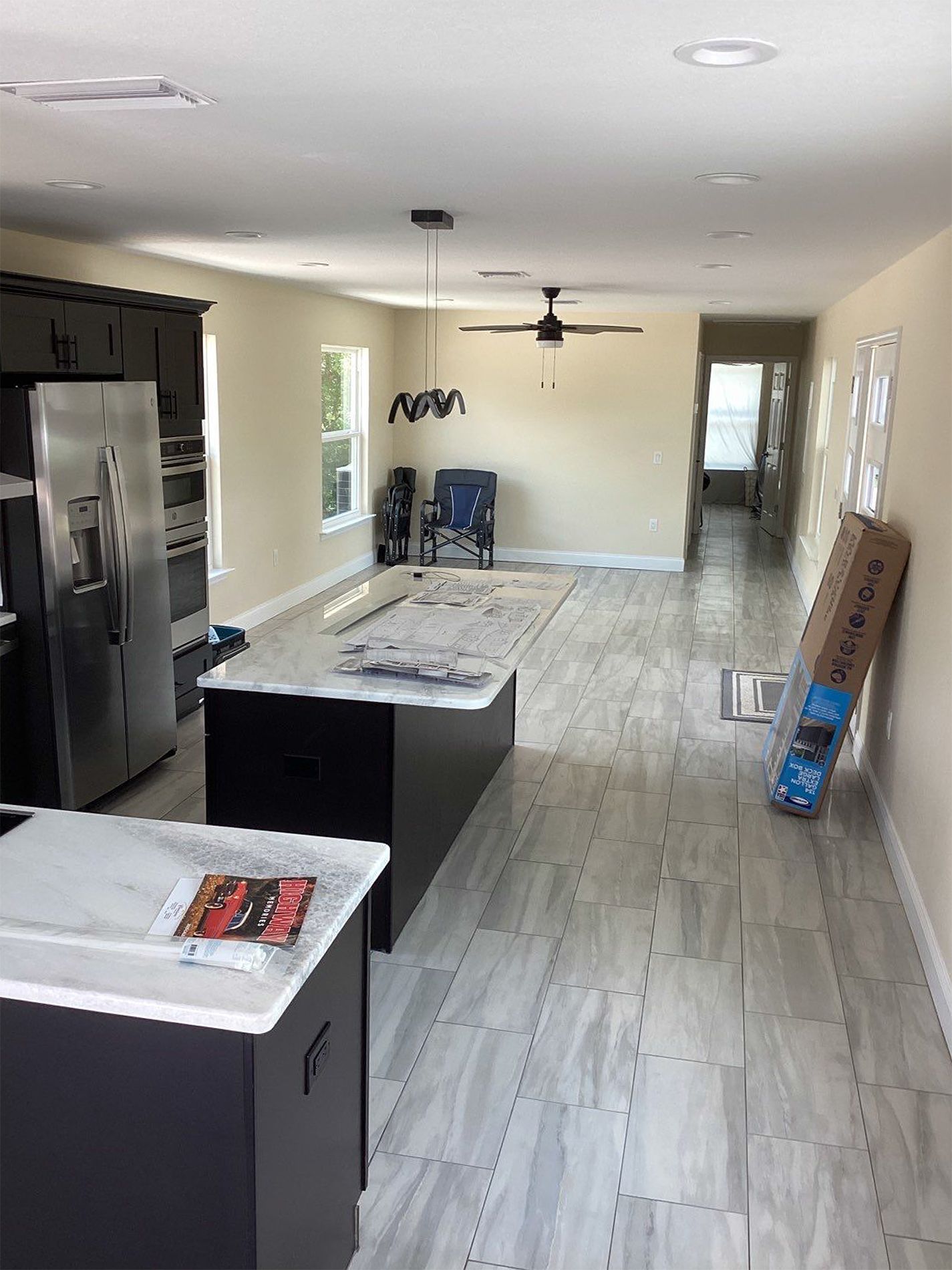 A kitchen with stainless steel appliances and a large island in the middle of the room.